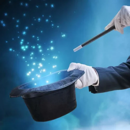 Magician or illusionist is showing magic trick. Blue stage light in background.